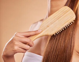 Hairbrush, hair care and woman brushing her hair in a studio for wellness, health and self care....