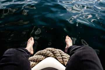 Füße vom Boot im Wasser