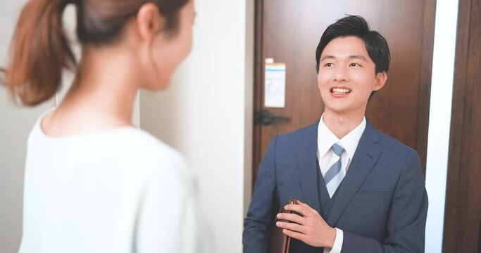 訪問販売をする若いビジネスマンと主婦