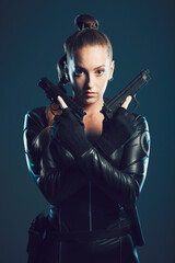 Woman, gun and assassin in studio portrait for costume, action or cyberpunk clothes. Girl, pistol and leather fashion for crime, gangster and futuristic spy with danger or future aesthetic with ninja