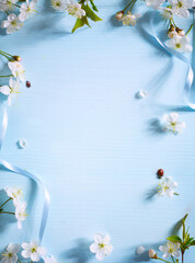 Art Spring flower border on blue background; white spring blossom border; Spring Floral Frame with copy space