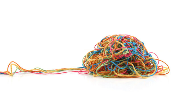 Tangled colorful cotton threads isolated on white background. Pile of knitting yarn threads.
