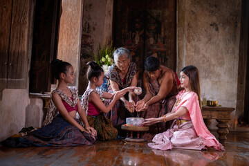 Asian people wearing Thai dress traditional pose happiness to playing splash water during Songkran festival is funny festival traditional holiday in Thailand 