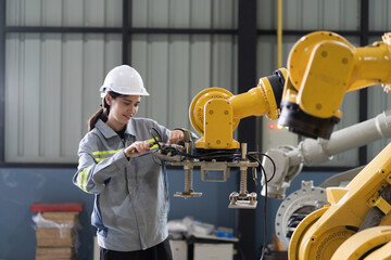 Industrial Manufacturing Robotic Arms Maintaining. Female engineer inspecting quality, repair,...
