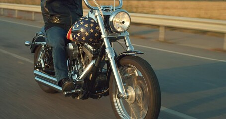 Close Up on a Vintage Custom Motorbike with American Flag Paint Driving on a Countryside Highway. Motorcyclist with Leather Jacket Riding his Motorcycle, Enjoying his Freedom, Doing a Road Trip