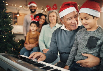 Family, christmas and grandfather with grandchild on piano for learning, teaching and bond in their...