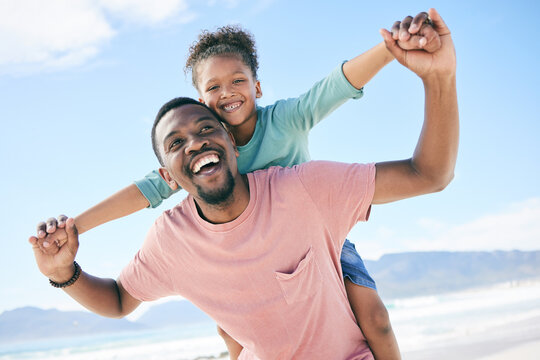 Beach, black man with child on piggy back and smile on playful family holiday in Australia with freedom and fun. Travel, happy father and girl playing, flying and bonding together on ocean vacation.