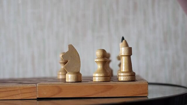 Close-up of the hand of a man playing chess, making move by knight in a chess