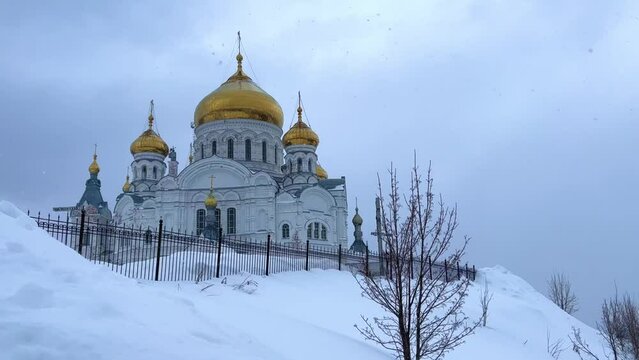 Belogorsky St. Nicholas Orthodox Missionary Monastery. Russia, Perm Krai, Belaya Gora. The temple on the hill in winter. Monastery on the background of snow. 4K