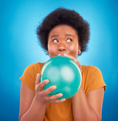 Fototapeta premium Balloon, happy and black woman in studio for celebration, good news or birthday on blue background. Party, blowing and girl with inflatable while celebrating, excited and having fun while isolated