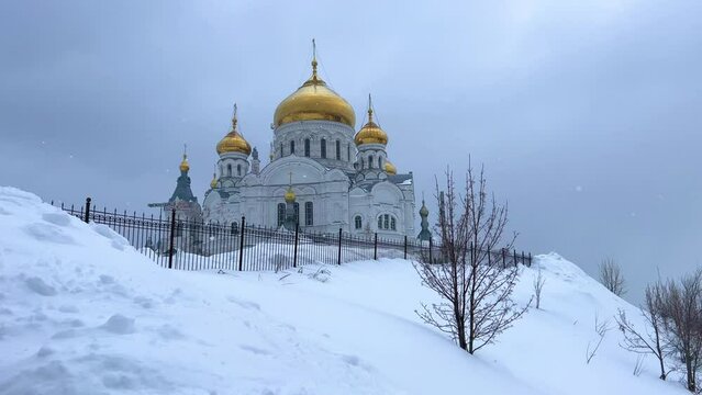 Belogorsky St. Nicholas Orthodox Missionary Monastery. Russia, Perm Krai, Belaya Gora. The temple on the hill in winter. Monastery on the background of snow. 4K