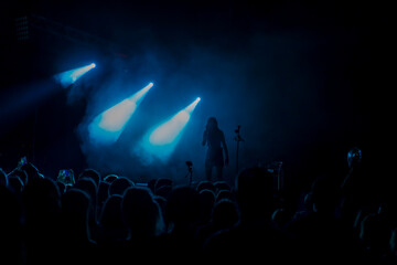 stage lights with smoke and a crowd of spectators