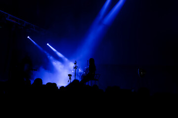 Fototapeta na wymiar stage lights with smoke and a crowd of spectators