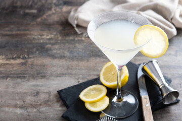 Lemon drop martini cocktail on wooden table. Copy space