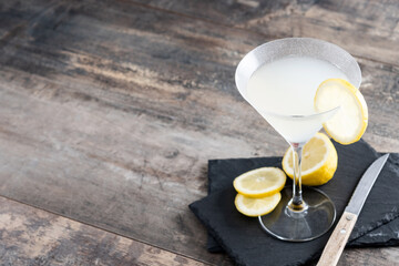 Lemon drop martini cocktail on wooden table. Copy space