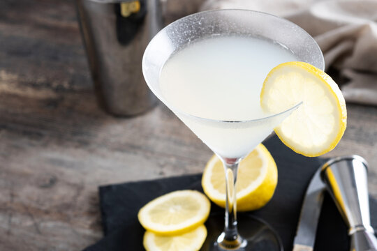Lemon drop martini cocktail on wooden table. Copy space