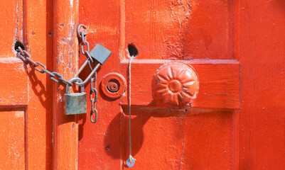 Padlock on the red wooden door. 