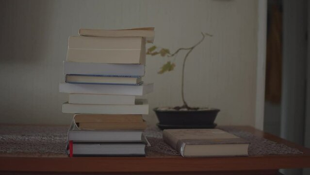 Grabbing a book from a stack of books plant in the back