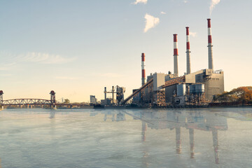 Industrial plant with chimneys reflecting in river