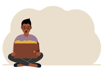 A man sits cross-legged and holds a large purse of coins. The concept of a savings wallet, a successful loan, golden earnings with metal money in the currency.