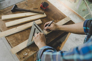 Hands of person doing diy project at home. Man measuring wood to doing cabinet craftworks as a hobby.