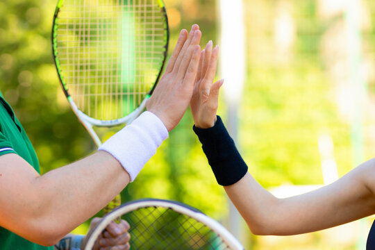 hands of couple tennis players playing on court. end of match. man and girl handshaking after match. daylight saving time family. healthy lifestyle, amateur sports, unusual date