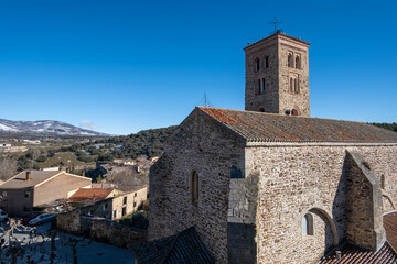 Fototapeta na wymiar Panorámica de la iglesia del pueblo madrileño buitrago de Lozoya con las montañas al fondo desenfocadas.