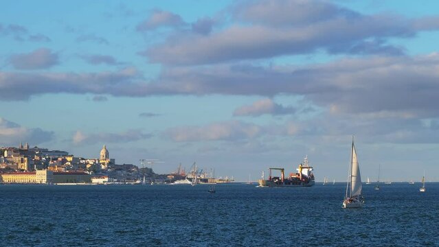 View of Lisbon over Tagus river from Almada with yachts and ferry boats and sea vessel on sunset. Lisbon, Portugal