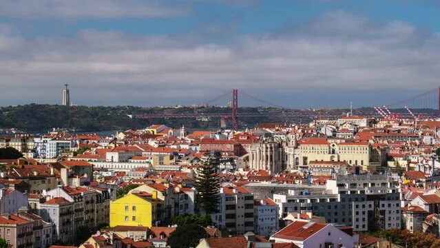 Time-lapse of Lisbon famous view from Miradouro dos Barros tourist viewpoint over Alfama old city district, 25th of April Bridge and Christ the King statue. Lisbon, Portugal. Camera pan effect