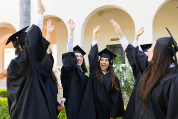 Cheerful young graduates celebrating during graduation