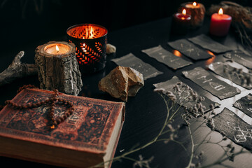 Black cards with magic signs laid out on a dark table. Halloween