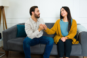Cheerful couple sitting on the sofa looking happy