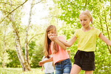 Fototapeta premium Girls in three legged race competition at garden