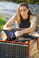 Woman uses photovoltaic and power station to generate electricity for laptop or notebook