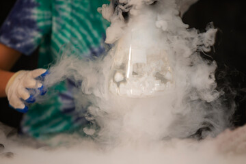 Glass flask with puffs of smoke as a result of liquid nitrogen reaction.