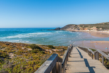 Viewpoint on blurred wooden pathway to sea and sand of Amoreira beach, Aljezur PORTUGAL