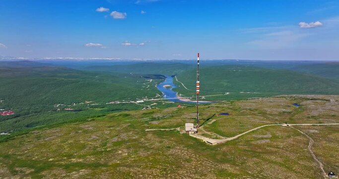 Aerial view away from a radio tower on top of the Ailikastunturi fell with the Teno river in the background, summer in Utsjoki, Finland