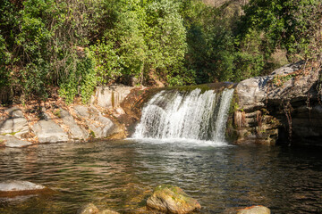 Water flowing over rocks in waterfall cascade in a forest. Silky water effect.