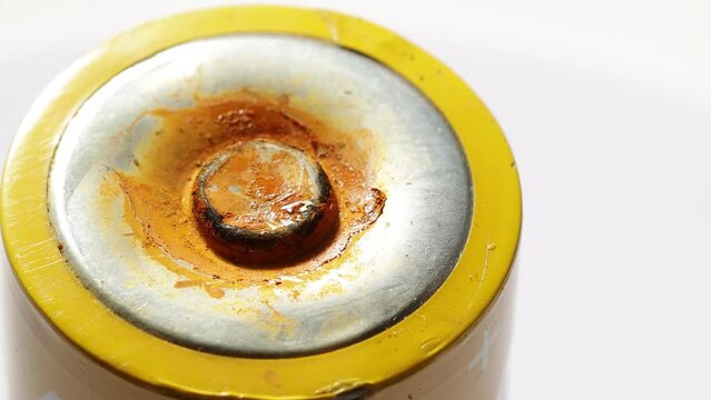 a failed electric battery with rust on a white background
