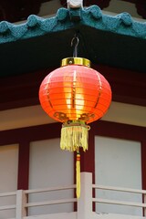 A Chinese lantern hanging on the side of a roof
