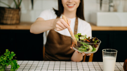 image of asian woman preparing salad in the kitchen and healthy  food in bowl e