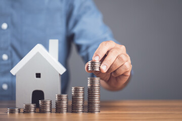 Money saving for house or Financial for real estate concept. Man stacking coin and small house...