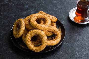 Traditional Turkish Crispy Sesame Rings which is eaten on Islamic holy nights on black plate with tea