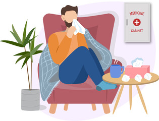 sick man possibly with cold or flu is at home on a sofa having a cup of tea or hot drink