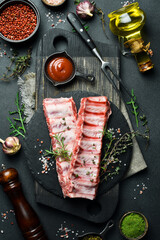 Fresh raw pork ribs with rosemary and spices. Ready to cook. Top view. Free space for text.