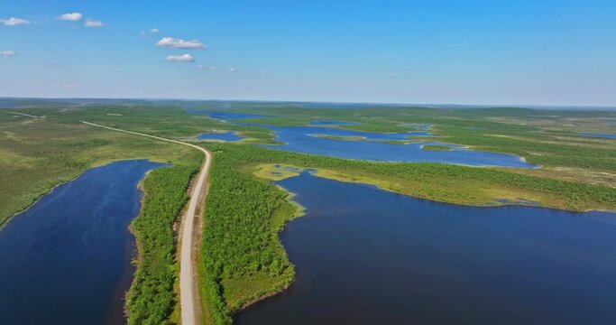 Aerial view of a road in middle of ponds and bogs of Kevo nature, summer in Lapland
