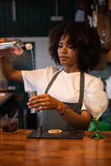 Young African bartender preparing a drink