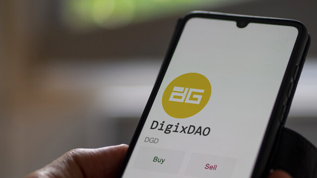 March 11 2023 London UK. An investor's analyzing the DigixDAO  coin on screen. A phone shows the crypto's prices to invest in DGD