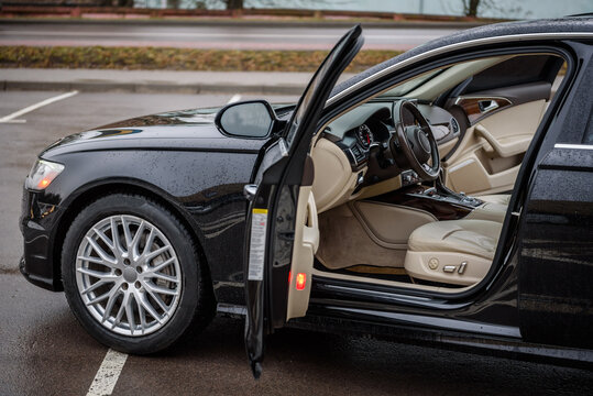 Side View Of The Open Driver's Door, Mirror, Dashboard Of The Car. Left Front Door. A New Modern Shiny Parked Black Car. Interior Luxury Car With Tinted Glass Standing At Parking. Modern Car Exterior.