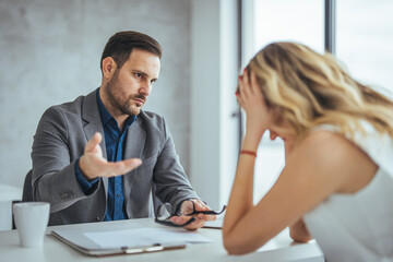 Manager is hard talking with employee in an office. Businessmen arguing at workplace, disagreeing over document, partners having conflict while negotiating, business deal failure